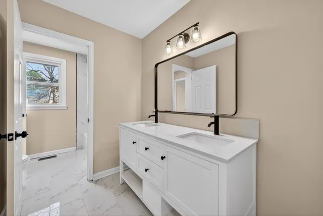 a bathroom with a double vanity sink and mirror