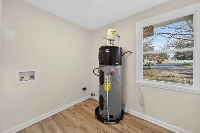 a view of a workspace with wooden floor and a window