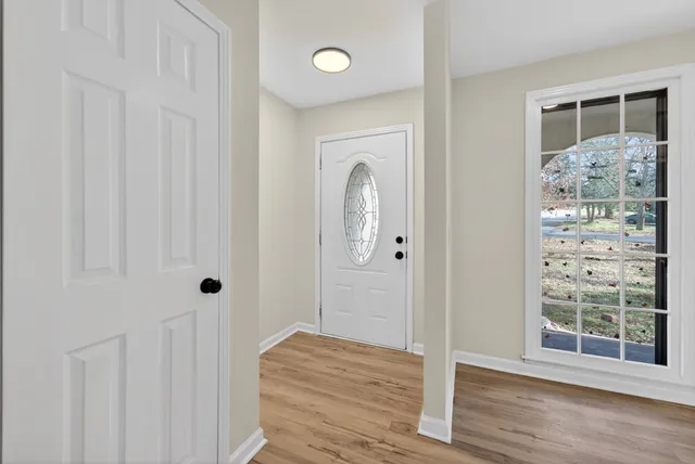 a view of a bathroom with wooden floor and window