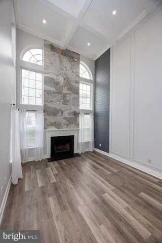 an empty room with windows and fireplace