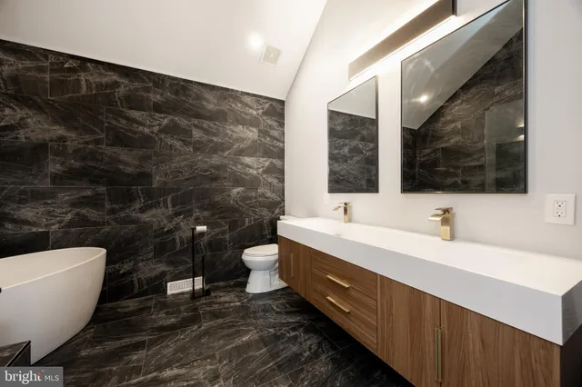 a bathroom with a double vanity sink mirror and bathtub