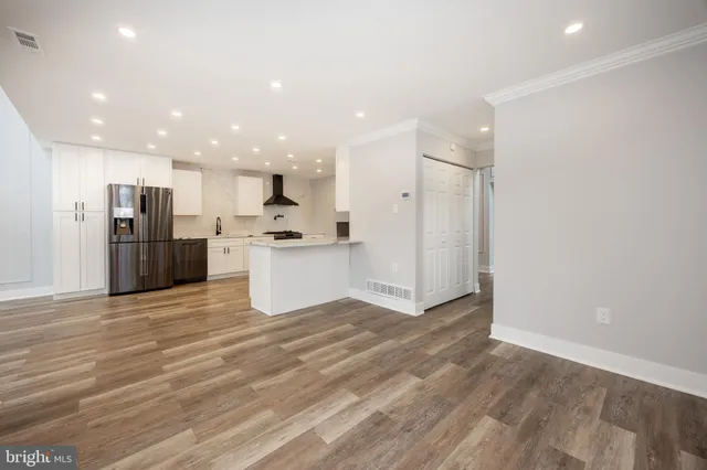 a view of kitchen view wooden floor stainless steel appliances and cabinets