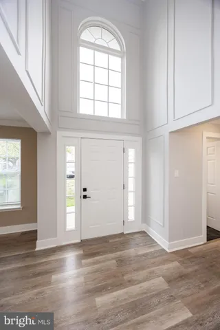 an empty room with wooden floor cabinet and windows
