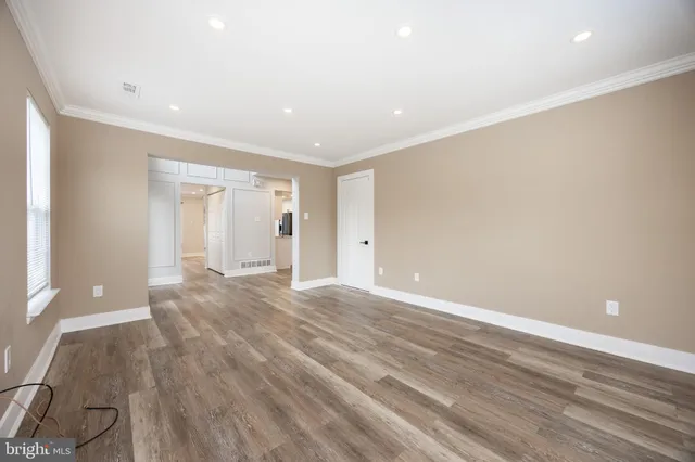 a view of an empty room with wooden floor
