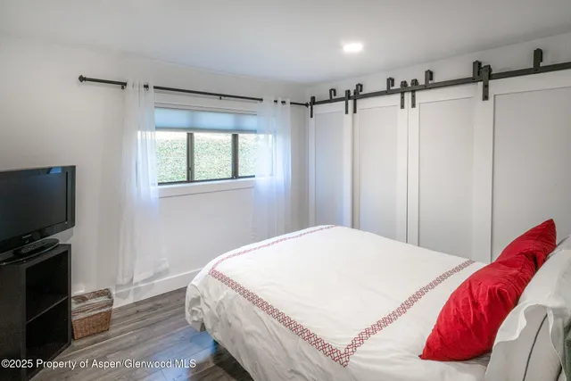 a bedroom with a bed and a flat screen tv