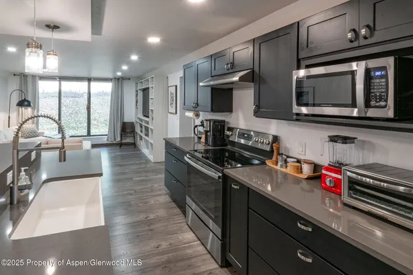 a kitchen with stainless steel appliances granite countertop a stove a sink and a microwave
