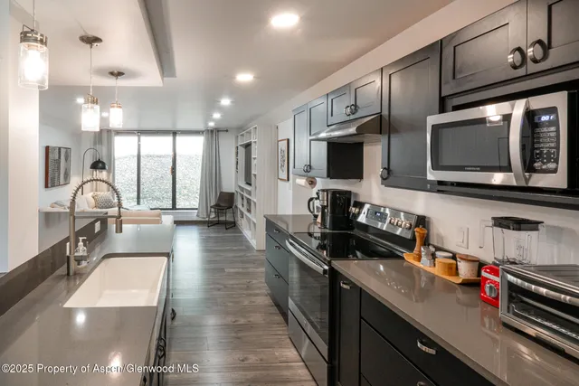 a kitchen with stainless steel appliances a stove sink microwave and cabinets