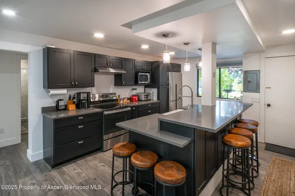 a kitchen with a sink a stove and chairs