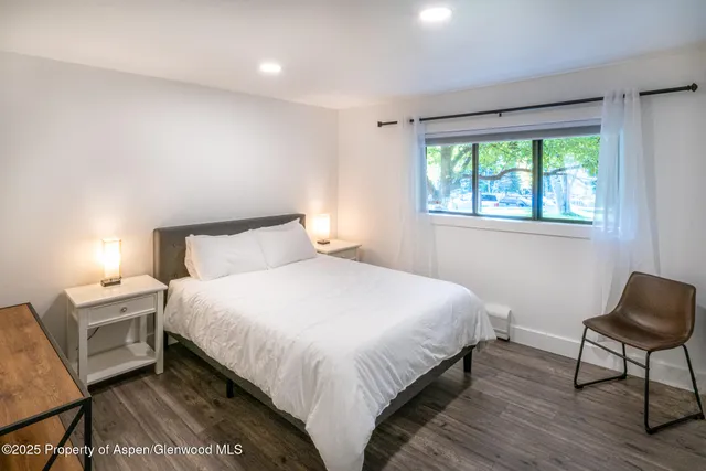 a bedroom with a bed a chair and a window