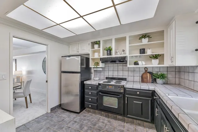 a kitchen with stainless steel appliances granite countertop a refrigerator and a stove
