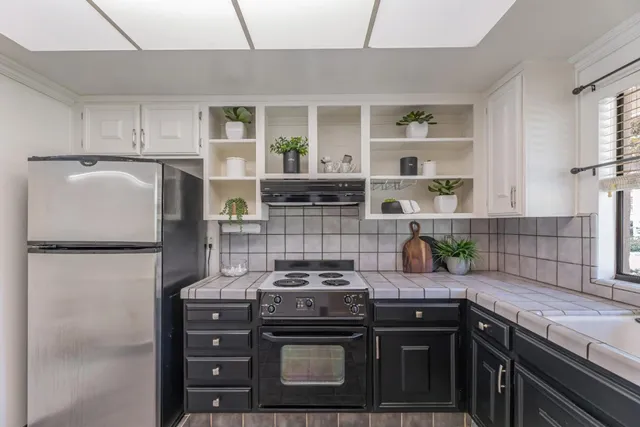 a kitchen with granite countertop a stove and a refrigerator