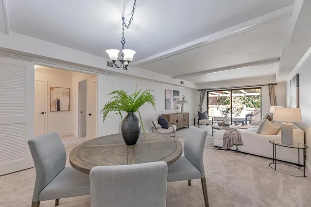 a dining room with furniture a chandelier and window