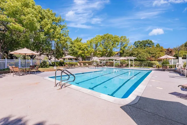 a view of a tennis ground with large trees