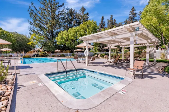 a view of a swimming pool with sitting area and furniture