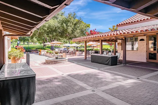 a view of a patio with table and chairs potted plants
