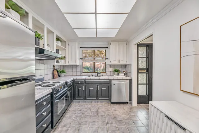 a kitchen with stainless steel appliances granite countertop a stove sink and cabinets