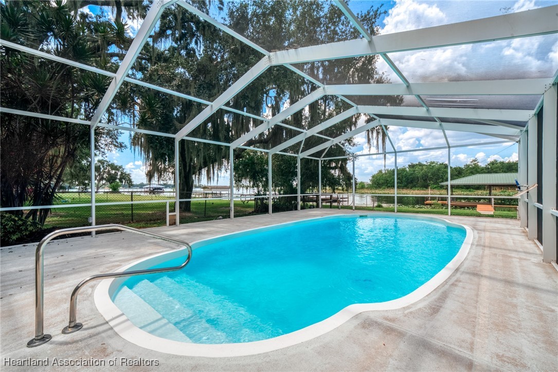 1630 Sentinel Road Sebring, FL 33875 - Photo 3 of 48 Enjoy the warm, sunny days in the sparkling blue, caged, in-ground pool overlooking the lake
