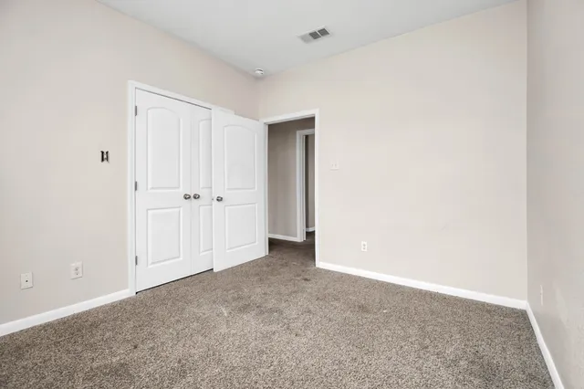 an empty room with white wall and closet
