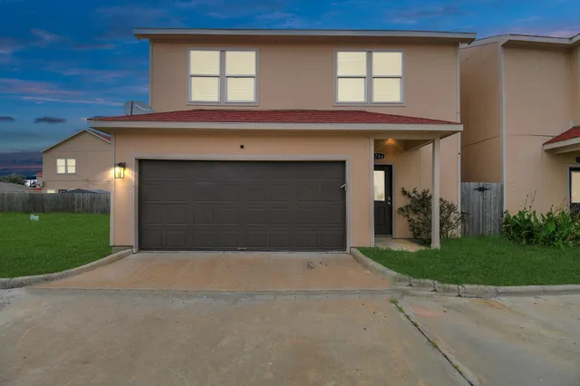 a front view of a house with a yard and garage