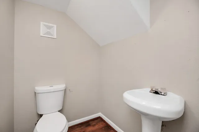 a bathroom with a toilet sink and mirror