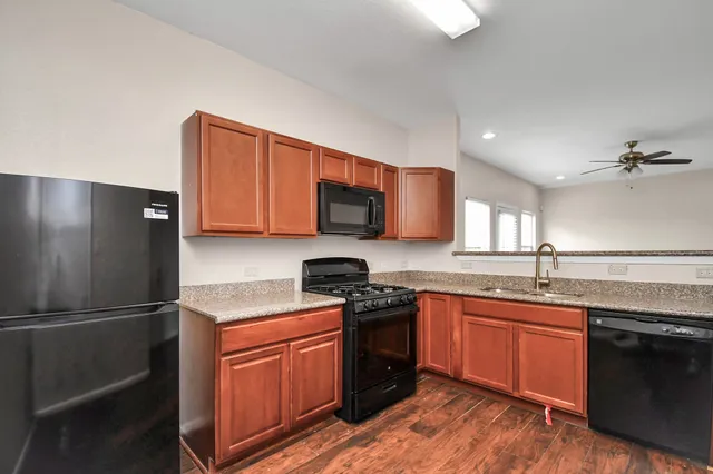 a kitchen with stainless steel appliances granite countertop a sink stove and refrigerator