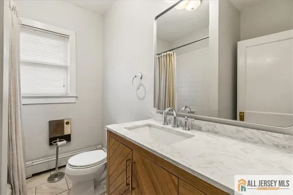 a bathroom with a granite countertop sink toilet and mirror