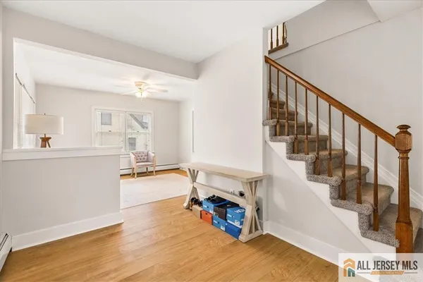a view of entryway and kitchen with wooden floor