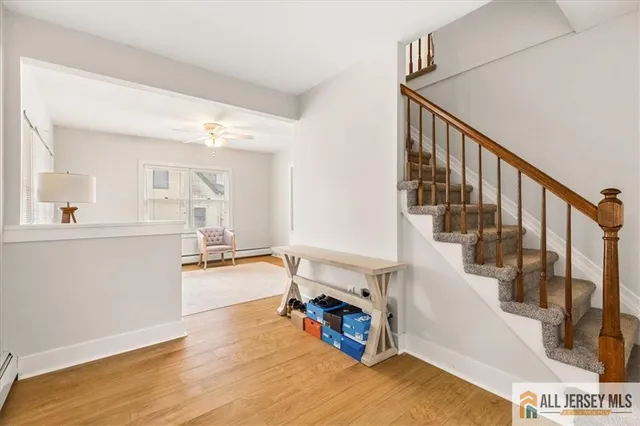 a view of entryway and kitchen with wooden floor