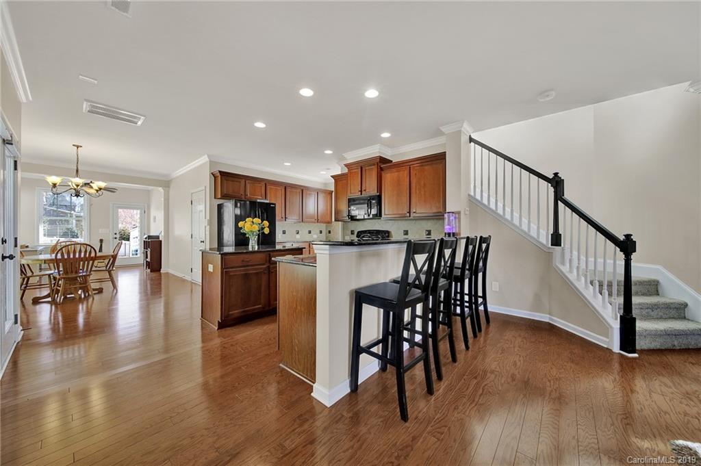 3550 Richard's Crossing Fort Mill, SC 29708 - Photo 8 of 33 a kitchen with stainless steel appliances kitchen island granite countertop a table and chairs in it