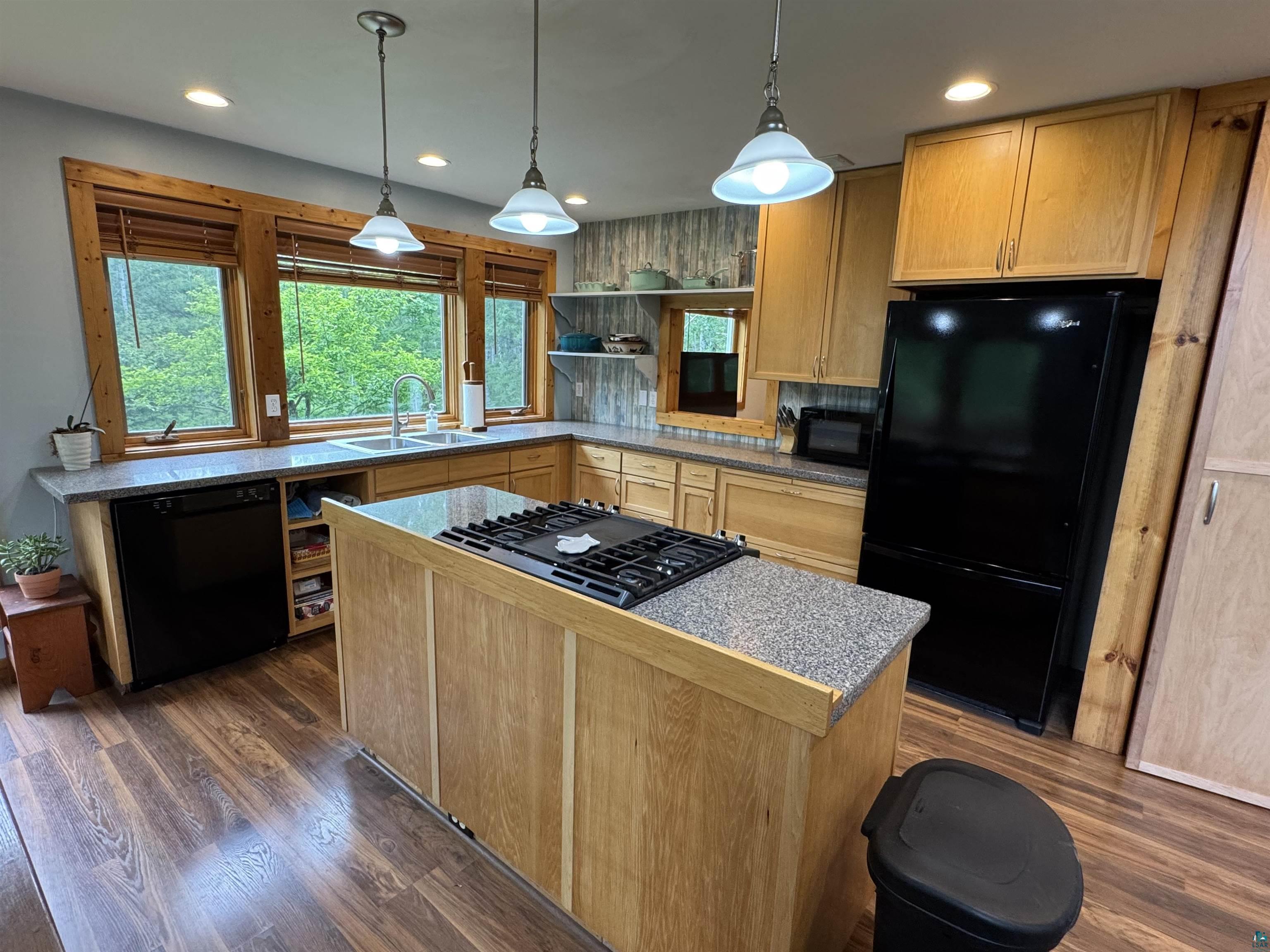 1745 Becks Road Maple, WI 54854 - Photo 16 of 46 Kitchen featuring light wood cabinetry, wood-finish flooring, and a central island with a built-in cooktop