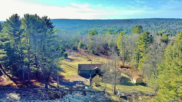 a view of a houses with trees and covered with wooden fence