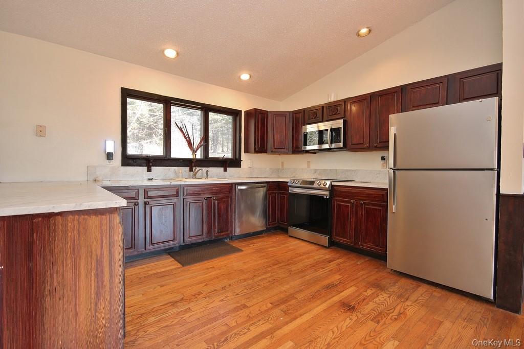 51 Forestburgh Road Forestburgh, NY 12777 - Photo 14 of 35 a kitchen with stainless steel appliances granite countertop a stove a sink dishwasher a refrigerator and a cabinets