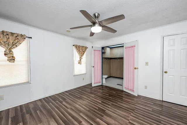 a view of a livingroom with wooden floor and a ceiling fan