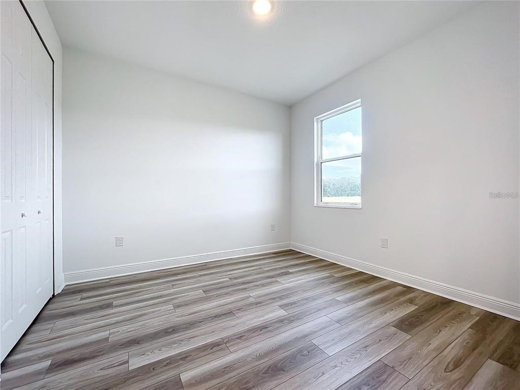 3951 Kennebunk Loop Mount Dora, FL 32757 - Photo 28 of 54 a view of an empty room with wooden floor and a window