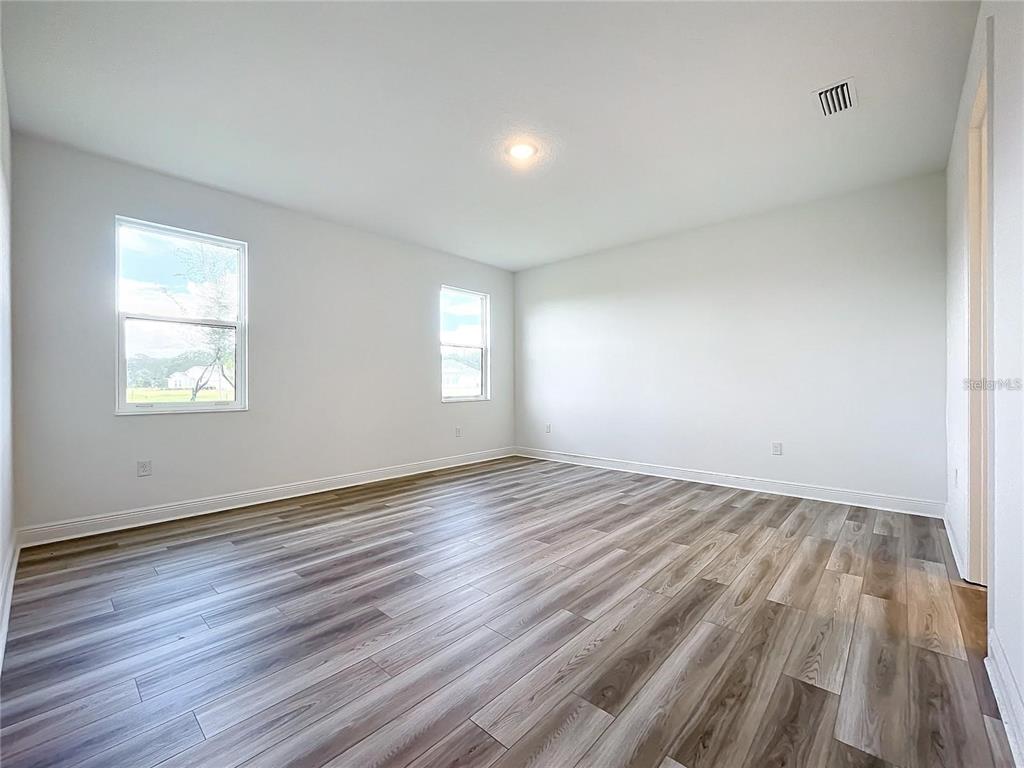 3951 Kennebunk Loop Mount Dora, FL 32757 - Photo 32 of 54 an empty room with wooden floor and windows