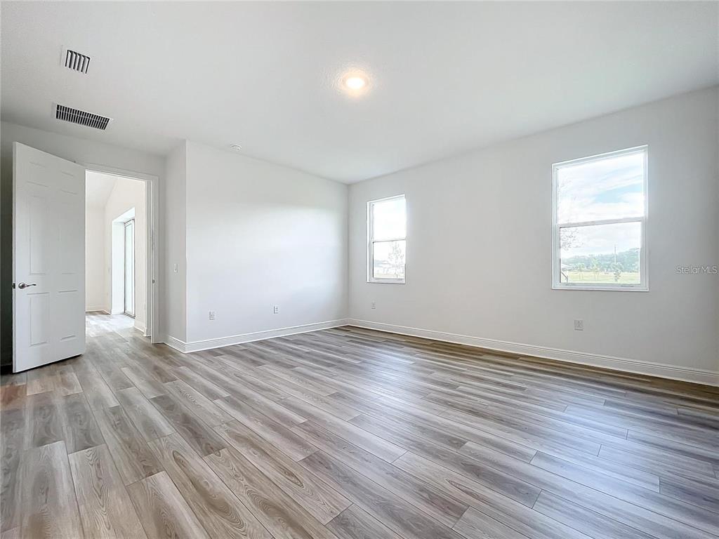3951 Kennebunk Loop Mount Dora, FL 32757 - Photo 35 of 54 an empty room with wooden floor and windows