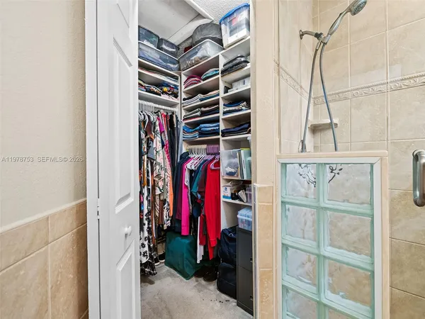a view of walk in closet with clothes