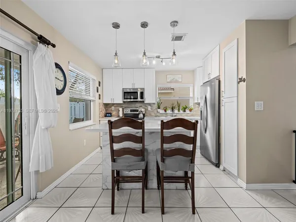 a kitchen with stainless steel appliances kitchen island granite countertop a refrigerator and a cabinets