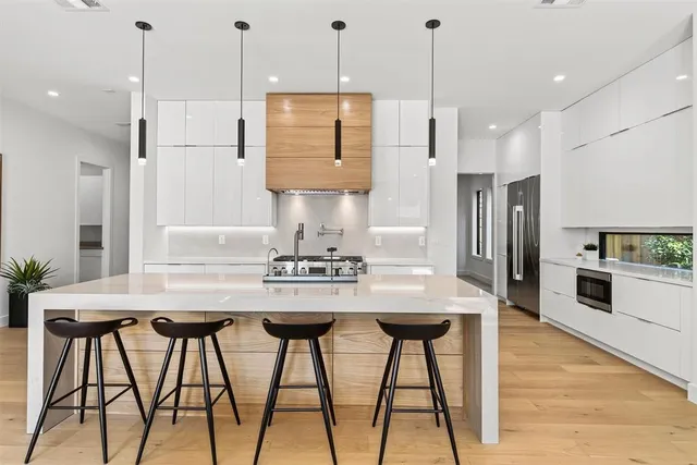 a kitchen with stainless steel appliances granite countertop white cabinets and wooden floor