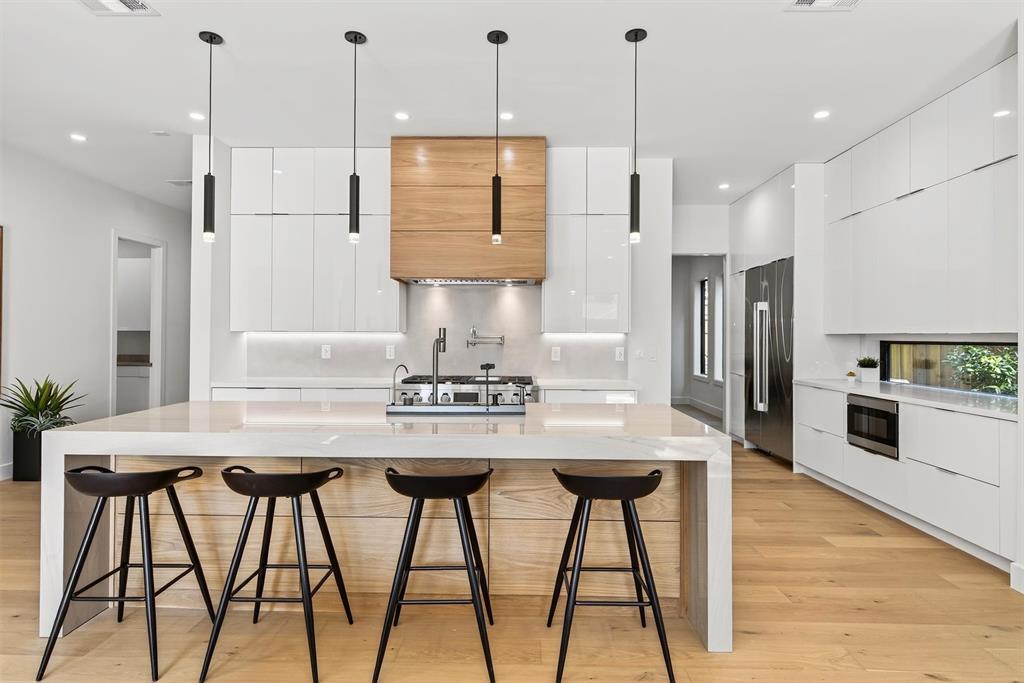 7619 Robin Road Dallas, TX 75209 - Photo 3 of 40 a kitchen with stainless steel appliances granite countertop white cabinets and wooden floor