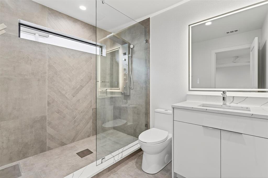 7619 Robin Road Dallas, TX 75209 - Photo 34 of 40 a bathroom with a shower sink vanity mirror and toilet