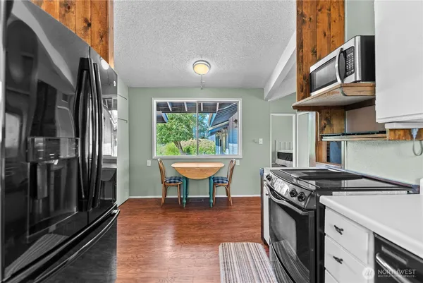 a kitchen with stainless steel appliances granite countertop a stove a sink and a refrigerator