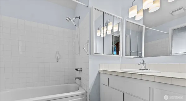 a bathroom with a sink a mirror and a bathtub