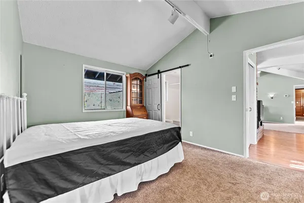a bedroom with a bed and a dresser with closet