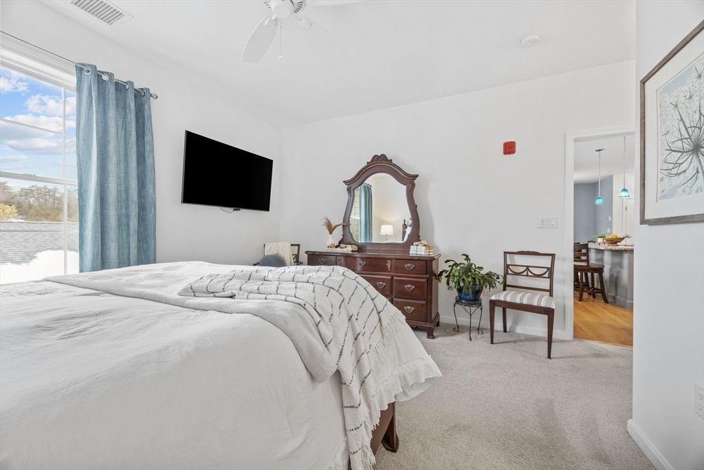 1 Mariner's Way, Unit 204 Plymouth, MA 02360 - Photo 17 of 36 a bedroom with a bed and a flat tv screen on wall