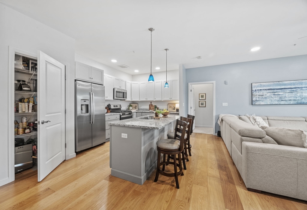 1 Mariner's Way, Unit 204 Plymouth, MA 02360 - Photo 3 of 36 a living room with stainless steel appliances kitchen island granite countertop furniture and a wooden floor