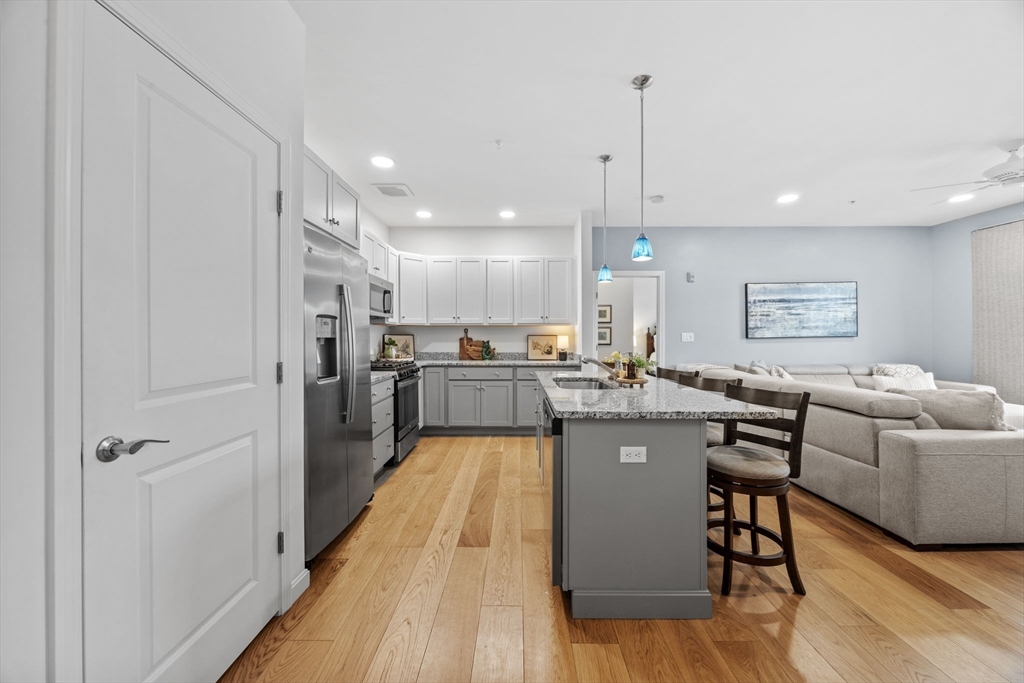 1 Mariner's Way, Unit 204 Plymouth, MA 02360 - Photo 6 of 36 a large kitchen with stainless steel appliances granite countertop a lot of counter space and a wooden floor