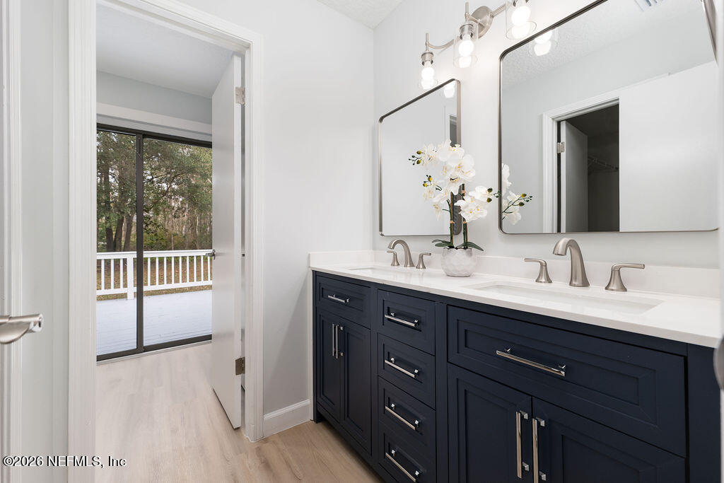 3819 Julington Creek Road Jacksonville, FL 32223 - Photo 12 of 36 a bathroom with a double vanity sink and mirror with shower