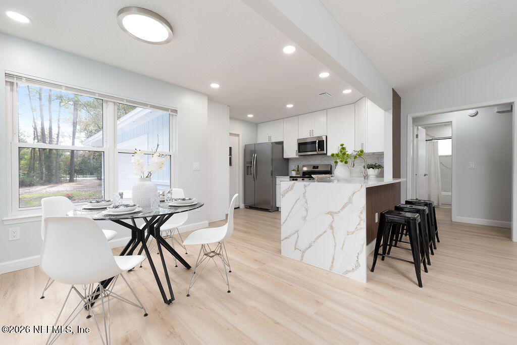 3819 Julington Creek Road Jacksonville, FL 32223 - Photo 6 of 36 a view of a dining room with furniture and a wooden floor