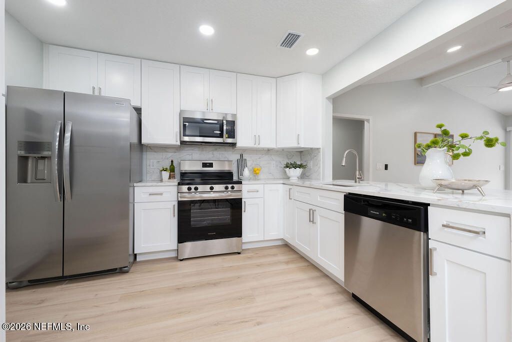 3819 Julington Creek Road Jacksonville, FL 32223 - Photo 8 of 36 a kitchen with a refrigerator sink and white cabinets